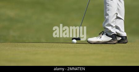 Playing golf preparing to shot, man putting on green Stock Photo