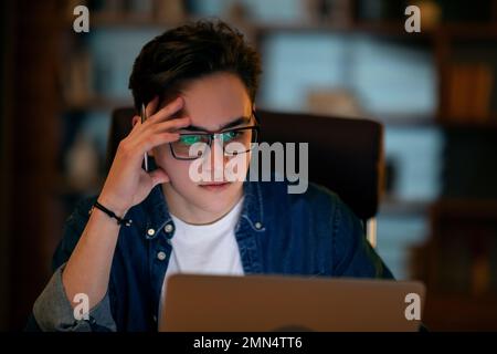 Young businessman working overtime alone in an office Stock Photo