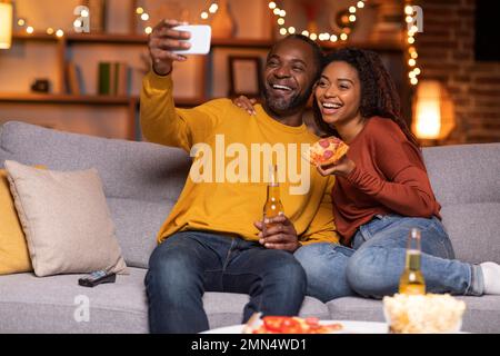 Happy black lovers taking selfie while having fun at home Stock Photo