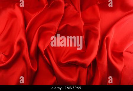 Red draped wavy pleated silk fabric background Stock Photo