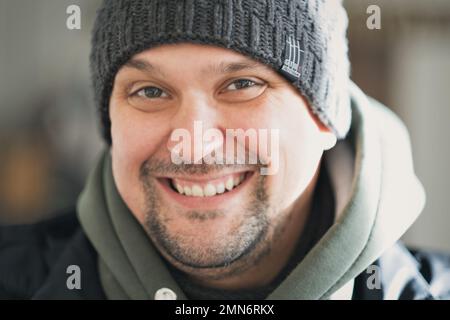 Portrait of a mature businessman wearing glasses on grey background. Happy senior latin man looking at camera isolated over grey wall with copy space. Close up face of happy successful business man.  Stock Photo