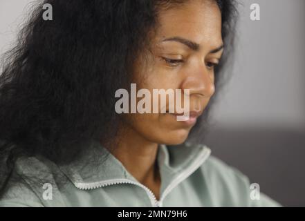 Natural looking black woman works on computer at home. Close up portrait of BIPOC female doing work on laptop Stock Photo
