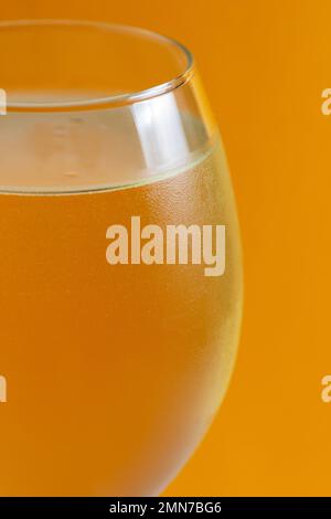 White wine in an ice glass with bubbles against a yellow background, in drink bar high-quality studio shot Stock Photo