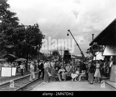 MADELEINE CARROLL FRED MacMURRAY Director EDWARD H. GRIFFITH and child actress CAROLYN LEE on set location candid with Movie Crew at railroad station in Howardsville, Virginia during filming of VIRGINIA 1941 director / story EDWARD H. GRIFFITH story / screenplay Virginia Van Upp cinematography Bert Glennon and William V. Skall Paramount Pictures Stock Photo