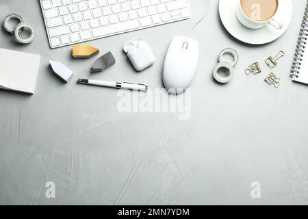 Flat lay composition with wired computer mouse and stationery on light grey table. Space for text Stock Photo