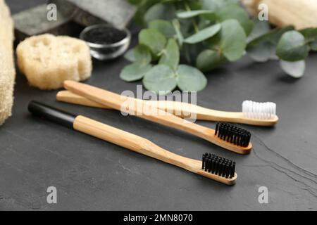 Toothbrushes made of bamboo on black stone table Stock Photo