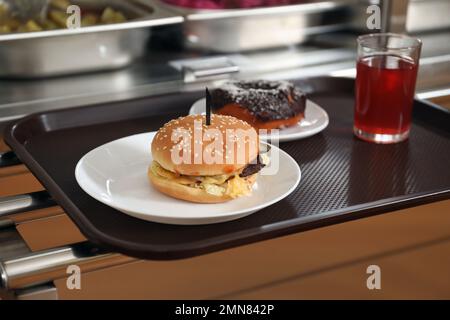 Plastic tray with tasty food near serving line in school canteen Stock Photo