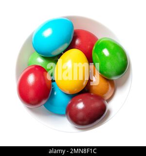 Multicolored Easter eggs in a white bowl. Group of rainbow colored Paschal eggs. Colorful dyed, hard boiled chicken eggs. Stock Photo
