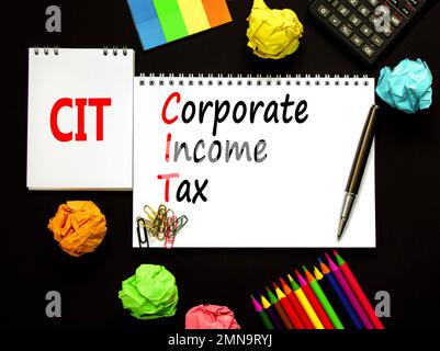 CIT corporate income tax symbol. Concept words CIT corporate income tax on white note on a beautiful black background. Calculator. Business and CIT co Stock Photo
