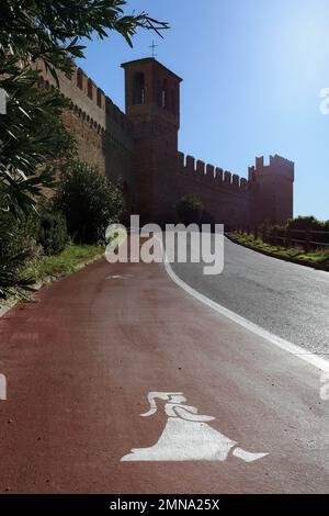 Funny pedestrian sidewalk in the medieval village of Gradara (Italy), with a middle age dressed lady over the white and red stripes of asphalt road, a Stock Photo