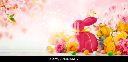Easter decoration with Easter eggs, bunny and spring flowers on white wooden table. Easter concept with copy space. Stock Photo