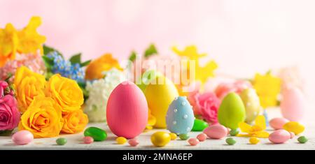Easter decoration with Easter eggs and spring flowers on white wooden table. Easter concept with copy space. Stock Photo