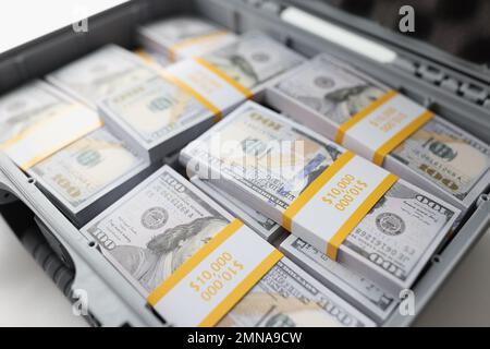 Close-up of briefcase full of stacks of dollar bills. Metal suitcase full of money. Stock Photo