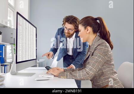 Two accountants working in office and looking at business spreadsheets on computer Stock Photo