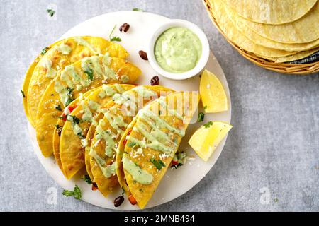 Crispy fried rice and beans tacos | Game day appetizer served with avacado cream sauce Stock Photo