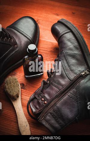 Concept of care and cleaning of vintage leather boots with wax, cream, sponge and brush Stock Photo
