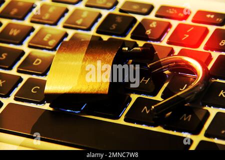 Computer keyboard with open padlock and hacker symbol on silhouette as background. Stock Photo
