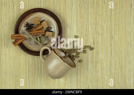 Cup with coffee beans and spices on a straw background. Top view. Space for text. Stock Photo