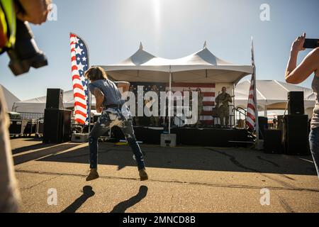 A Northern California resident dances while Band of the Golden West’s Mobility Rock Band plays during the California Capital Airshow at Mather Airport in Sacramento, California, Oct. 1, 2022. Airmen representing various units from Travis Air Force Base participated in the event to educate, inspire and share the mission of Air Mobility Command and displayed a static KC-10 Extender, C-5M Super Galaxy and C-17 Globemaster III. Stock Photo