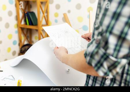 Self-assembly furniture concept. The young man himself assembling chairs Stock Photo