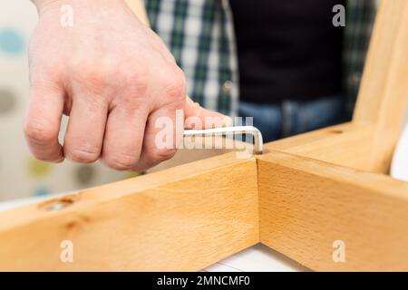 Self-assembly furniture concept. The young man himself assembling chairs Stock Photo