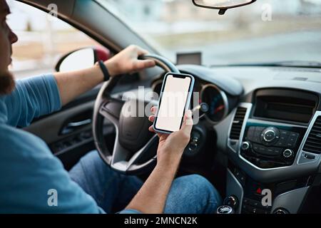 Screen blank mockup mobile phone in the hands of a man driver in a car Stock Photo