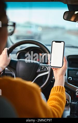 Screen blank mockup mobile phone in the hands of a woman driver in a car Stock Photo