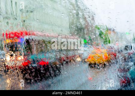 Bad weather, rain, street traffic photographed through wet glass. Stock Photo