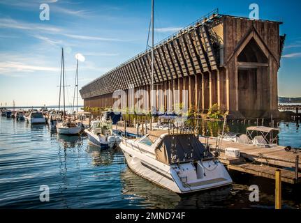 Boat Marina pier with sail boats tied next to old historic  iron ore ship loading dock Stock Photo