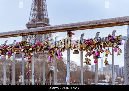 Love locks line the railings of the Debilly Footbridge, a pedestrian bridge crossing the Seine river near the Eiffel Tower. Stock Photo