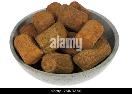 Dutch cinnamon candy sticks in a concrete bowl isolated on white background Stock Photo