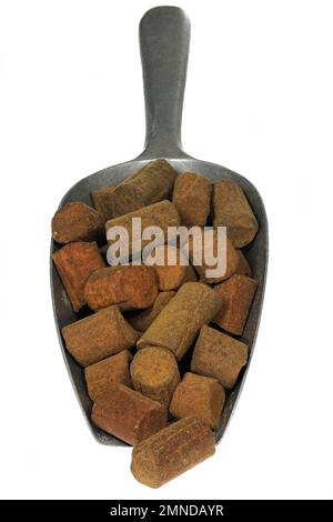 Dutch cinnamon candy sticks in a weighing scoop isolated on white background Stock Photo