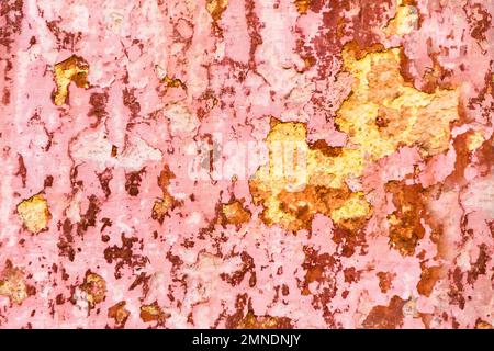 Rough plastered wall with peeling red paint Stock Photo