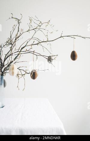Easter paper eggs hanging on branches. Easter tablescape decor. Stock Photo