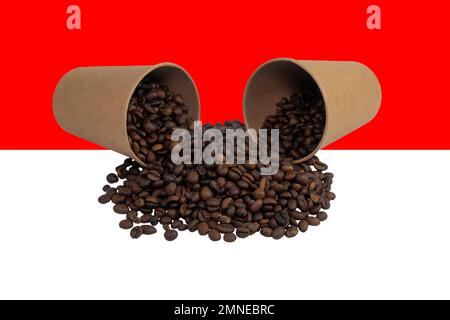 Two overturned disposable paper cups filled with roasted coffee beans against the background of the Indonesian flag (close-up) Stock Photo