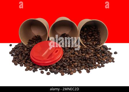 Three overturned disposable paper cups filled with roasted coffee beans against the background of the Indonesian flag (close-up) Stock Photo