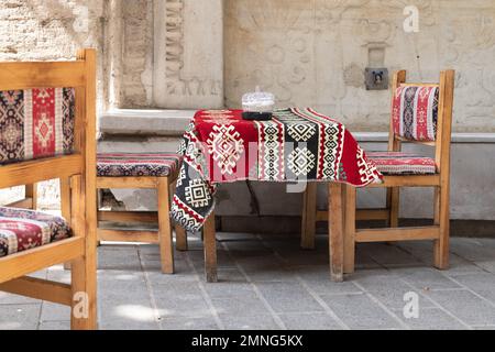 Kilim fabric textile tablecloth and chairs outside cafe, Istanbul, Turkey Stock Photo