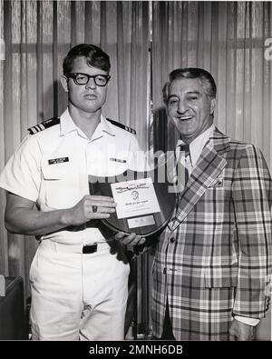 Lieutenant Commander J.R. Beene receives a plaque from entertainer Danny Thomas in recognition of the naval officer's role in providing blood platelets to St. Jude Children's Research Hospital ca. August 1975 Stock Photo