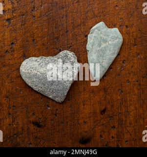 Heart shaped stones on wooden surface Stock Photo