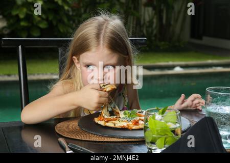 Little girl eating pizza Margherita at the restaurant Stock Photo