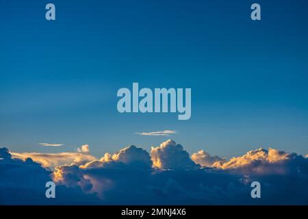 Cumulus clouds on blue sky at sunrise Stock Photo