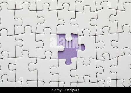 Piece missing from white jigsaw puzzle Stock Photo