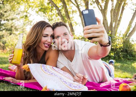 Smiling couple taking selfie in park Stock Photo