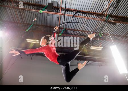 Young acrobat performing on aerial hoop Stock Photo