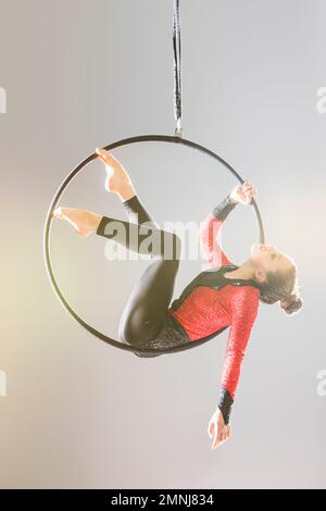 Young acrobat performing on aerial hoop Stock Photo