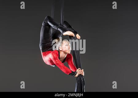 Young acrobat performing on aerial silks Stock Photo