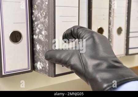 thief stealing ring binder and confidential files in an office Stock Photo