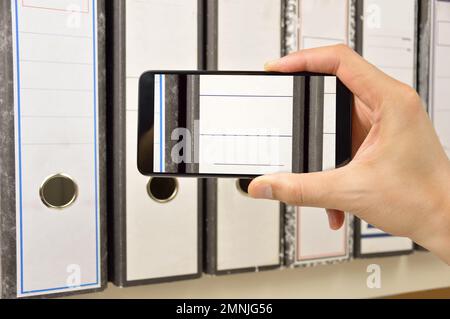businessman taking photo of documents with smart phone in connection with industrial espionage Stock Photo