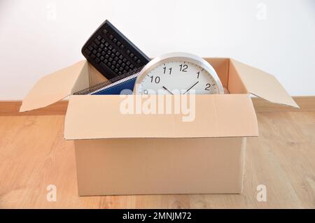 Office accessories in a cardboard box at office. Stock Photo