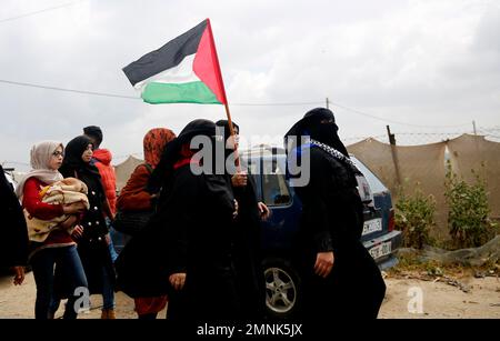 Palestinian women holding a Palestinian flags during a demonstration near the Gaza Strip border with Israel, in eastern Gaza City, Friday, March 30, 2018. Palestinians clashed with Israeli troops along the Gaza border Friday morning as thousands gathered there for mass sit-ins led by the militant Islamic group Hamas that rules the territory. (AP Photo/Hatem Moussa)